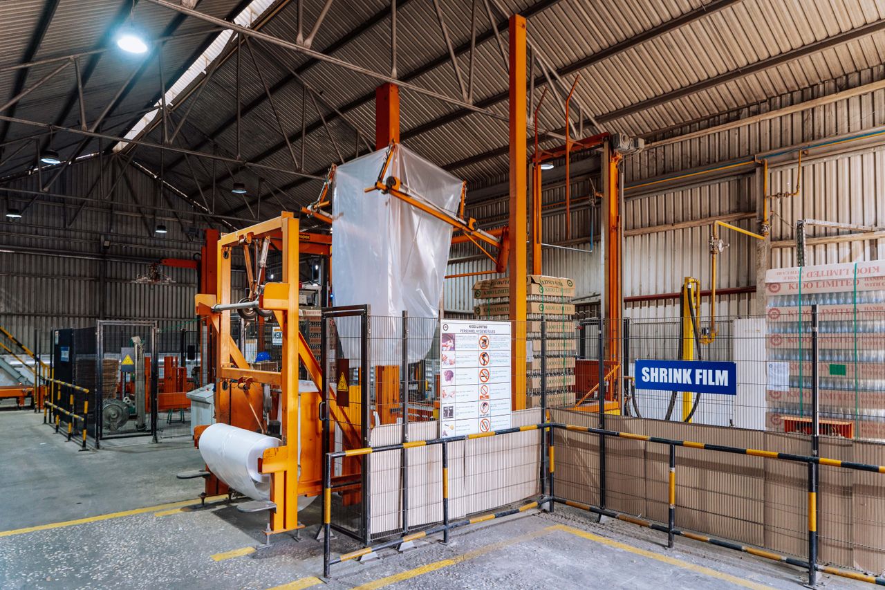 Home Interior view of a warehouse in Dar es Salaam with a shrink film machine and industrial equipment.