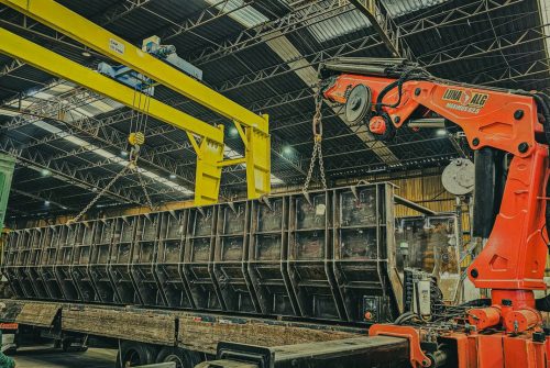 pexels photo 31856778 31856778 A large crane is used to load a container onto a truck inside a warehouse.